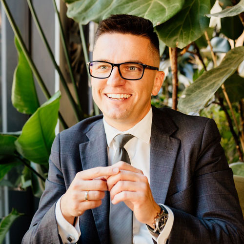 Piotr Grudniewski uśmiecha się i patrzy przed siebie