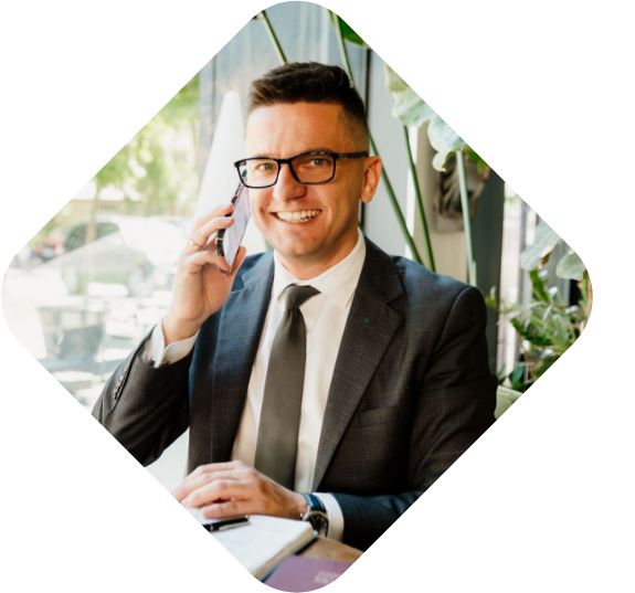 Piotr Grudniewski z telefonem w ręce rozmawia z klientem